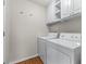 Bright laundry room with overhead cabinets and modern washer and dryer at 7045 Threadstone Overlook, Johns Creek, GA 30097