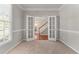 Home office with double french doors, carpet, and neutral paint at 7045 Threadstone Overlook, Johns Creek, GA 30097