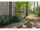 A concrete sidewalk winds through mature trees and landscaping in the side yard at 7045 Threadstone Overlook, Johns Creek, GA 30097