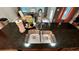 Close up on a deep stainless steel sink, black granite countertop, and gooseneck faucet at 81 Richmond Way, Villa Rica, GA 30180
