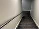 Carpeted staircase with a metal handrail leading to the lower level at 81 Richmond Way, Villa Rica, GA 30180