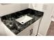 Bathroom vanity with a striking black and white granite countertop and white cabinets at 81 Richmond Way, Villa Rica, GA 30180