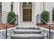 Stone steps lead to a welcoming front entrance with a black iron railing and symmetrical landscaping at 98 Sheridan Dr, Atlanta, GA 30305