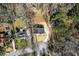 Bird's eye view of a home with a dark roof, set amidst trees, featuring a long driveway and lush surroundings at 5017 Tanaga Ct, Stone Mountain, GA 30087