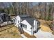 Aerial view of a modern home with a deck, garage, and driveway surrounded by lush trees in a serene setting at 5017 Tanaga Ct, Stone Mountain, GA 30087
