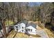 A high angle showcases a modern home nestled among trees, with a driveway and deck, offering a private retreat at 5017 Tanaga Ct, Stone Mountain, GA 30087