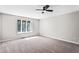 Spacious bedroom with neutral carpet, a ceiling fan, and a large window providing natural light at 5017 Tanaga Ct, Stone Mountain, GA 30087