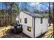 Beautiful two-story home with a deck and black trim, nestled among tall trees on a sunny day at 5017 Tanaga Ct, Stone Mountain, GA 30087