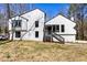 Charming exterior view of a two-story home with white siding and a well-maintained lawn in a wooded area at 5017 Tanaga Ct, Stone Mountain, GA 30087