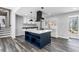 Kitchen with island, white cabinets, modern lighting, and wood-look flooring at 5017 Tanaga Ct, Stone Mountain, GA 30087