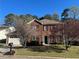 Charming two-story brick home featuring a well-manicured lawn and mature flowering trees at 5942 King Way Walk, Lithonia, GA 30058