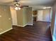 Spacious living room with wood floors, a ceiling fan, and access to the kitchen at 5942 King Way Walk, Lithonia, GA 30058