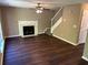 Bright living room featuring wood floors, a fireplace, and a staircase to the upper level at 5942 King Way Walk, Lithonia, GA 30058