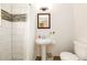Bright bathroom with a walk-in shower, decorative tiling, a pedestal sink, and a modern toilet at 1448 N Highland Ne Ave, Atlanta, GA 30306
