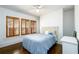 Comfortable bedroom with hardwood floors, a queen bed, and three windows with wooden shutters at 1448 N Highland Ne Ave, Atlanta, GA 30306