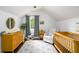 Bedroom room with light walls, a crib, a dresser, a rocking chair, and a decorative rug at 1448 N Highland Ne Ave, Atlanta, GA 30306
