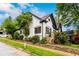 Angle-view of a charming two-story home with white painted brick, dark trim, and landscaped yard at 1448 N Highland Ne Ave, Atlanta, GA 30306