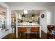 Kitchen island featuring granite countertop with seating, a view into the kitchen, and a staircase at 1448 N Highland Ne Ave, Atlanta, GA 30306