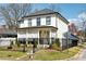 Charming two-story home with a covered porch, manicured lawn, and black metal fencing at 969 Parsons Sw St, Atlanta, GA 30314
