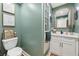 Stylish powder room with sage green walls, white vanity and gold fixtures at 969 Parsons Sw St, Atlanta, GA 30314