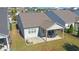 Aerial view showcasing backyard with covered patio, outdoor dining, and landscaping at 5638 Maple Bluff Way, Hoschton, GA 30548