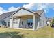 Charming backyard with a covered patio, perfect for outdoor dining and entertaining, complemented by lush green lawn at 5638 Maple Bluff Way, Hoschton, GA 30548