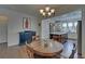 Cozy dining room with hardwood floors and open view to modern kitchen and center island at 5638 Maple Bluff Way, Hoschton, GA 30548