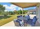 Relaxing covered patio featuring an outdoor dining set and a serene view of the expansive, well-maintained lawn at 5638 Maple Bluff Way, Hoschton, GA 30548