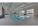 Indoor swimming pool with lane markers, large windows, and lounge chairs at 5638 Maple Bluff Way, Hoschton, GA 30548