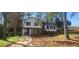 Two-story home showcasing a stone foundation, light siding, and dark shutters and trim at 1 Hidden Valley Dr, Lawrenceville, GA 30044