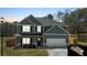 Charming two-story home with gray siding, a two-car garage, and a well-manicured lawn at 261 Webster Lake Dr, Temple, GA 30179