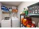 A well-organized laundry room with washer, dryer, and shelving with various household items at 261 Webster Lake Dr, Temple, GA 30179