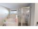A bathtub and shower enclosed with modern marble tile and glass doors at 261 Webster Lake Dr, Temple, GA 30179