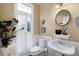 Well-lit bathroom featuring white wainscoting, a pedestal sink, and plantation shutters at 1020 Constitution Way, Cumming, GA 30040