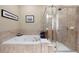 A bathroom featuring a soaking tub and glass-enclosed shower with tile surround at 1020 Constitution Way, Cumming, GA 30040