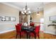 A cozy dining room with a round table, bright red chairs, and neutral colored walls at 1020 Constitution Way, Cumming, GA 30040
