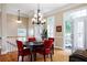 Bright dining room featuring hardwood floors, modern chandelier, and French doors leading to a balcony at 1020 Constitution Way, Cumming, GA 30040
