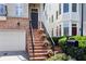 Inviting townhome entrance with brick stairs, black railing, and attached garage at 1020 Constitution Way, Cumming, GA 30040