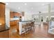 Open kitchen with counter seating and stainless appliances flows into the living room with hardwood floors at 1020 Constitution Way, Cumming, GA 30040