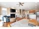 Open-concept living space with fireplace, hardwood floors, leading to a kitchen and staircase at 1020 Constitution Way, Cumming, GA 30040