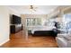 Spacious main bedroom with hardwood floors, ceiling fan, and a large window overlooking the trees at 1020 Constitution Way, Cumming, GA 30040