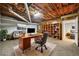 Finished basement office space with exposed ceiling, natural wood bookshelf and adjacent bedroom at 2051 E Piedmont Rd, Marietta, GA 30062