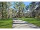 Long private driveway leading to a secluded home, surrounded by mature trees and green lawns at 2051 E Piedmont Rd, Marietta, GA 30062