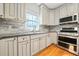 Renovated kitchen with stone countertops, stainless steel appliances, light grey cabinetry, and hardwood floors at 2051 E Piedmont Rd, Marietta, GA 30062