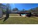 A spacious lawn shows a in-ground pool and patio space with a covered dining area at 3007 Hidden Dr, Lawrenceville, GA 30044