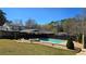 Backyard in-ground pool with spa, stone patio, with mature trees in the background at 3007 Hidden Dr, Lawrenceville, GA 30044