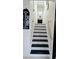 Well-lit staircase with black and white accents, handrails, and views of a hallway with stylish decor at 3007 Hidden Dr, Lawrenceville, GA 30044
