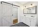 Bathroom with double sink vanity, gray tile floor, and barn door to closet space at 793 Joseph E Boone Nw Blvd, Atlanta, GA 30314