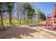 Expansive backyard with mature trees, wooden deck, and space for activities at 1913 Shenley Park Ln, Duluth, GA 30097