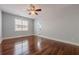 Spacious bedroom with hardwood floors, ceiling fan, and a sunlit window with bright white trim at 1913 Shenley Park Ln, Duluth, GA 30097